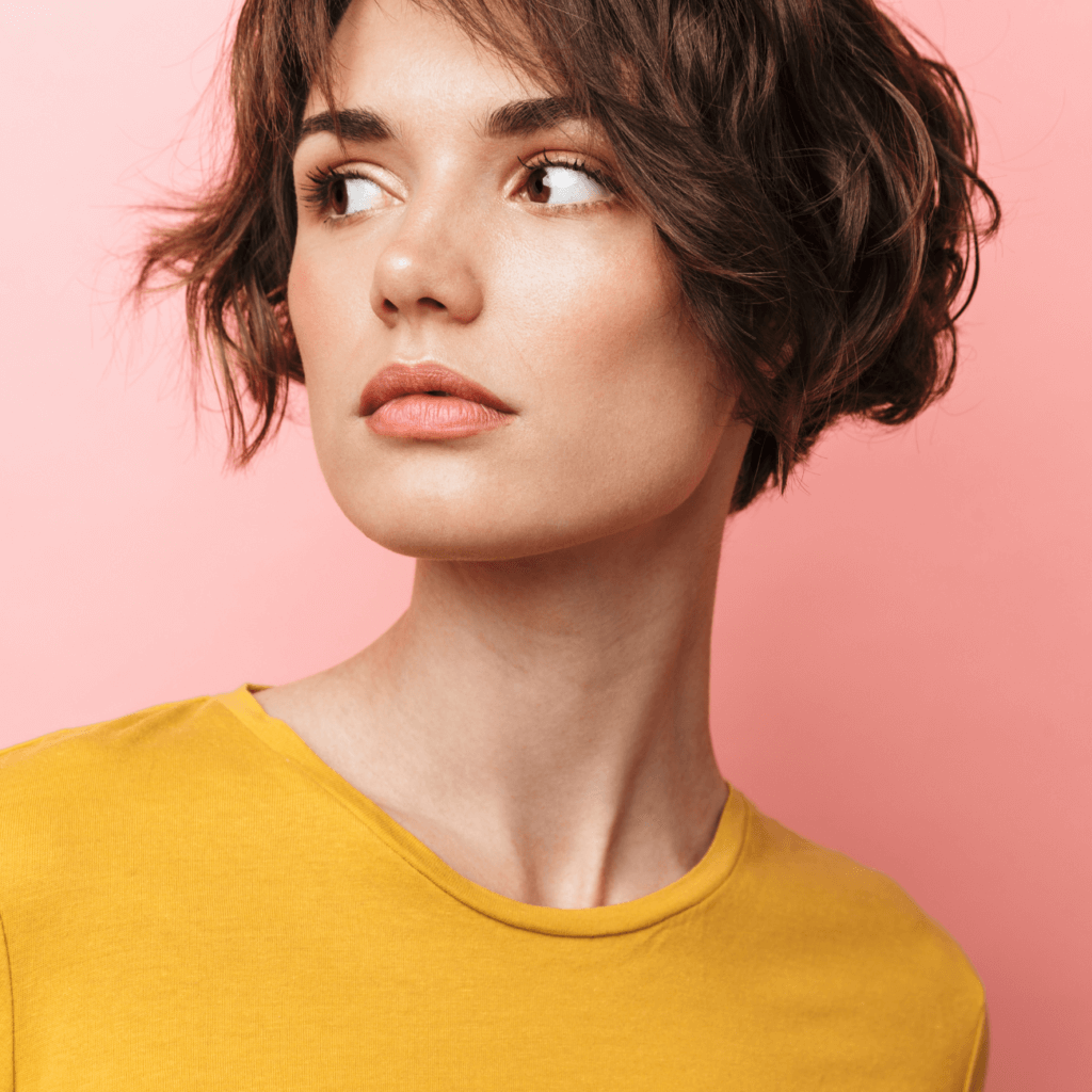 mujer con cabello corto fondo de color rosa